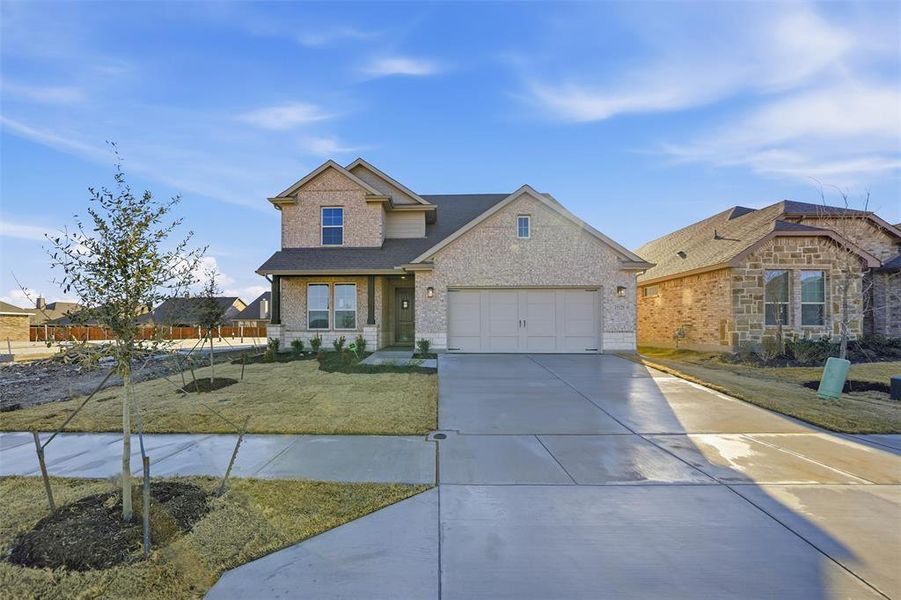 View of front facade with brick siding, driveway, and a shingled roof View of front facade with brick siding, driveway, and a shingled roof