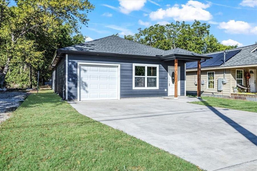 Ranch-style house with a garage and a front lawn