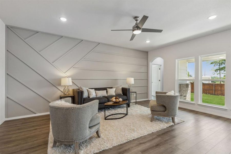 Living room with dark hardwood / wood-style flooring and ceiling fan