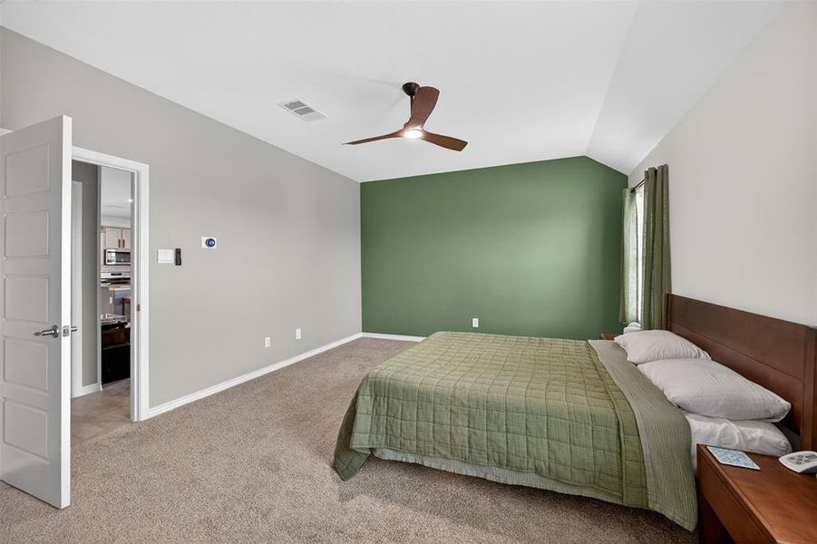 Bedroom with lofted ceiling, light carpet, and ceiling fan