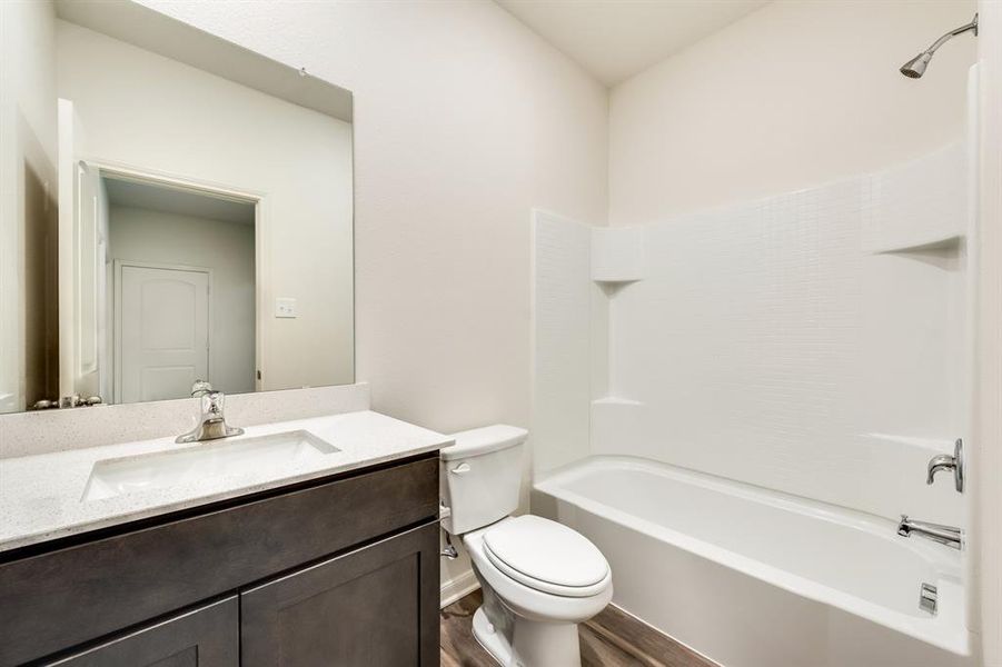 Full bathroom with wood-type flooring, toilet, shower / washtub combination, and vanity