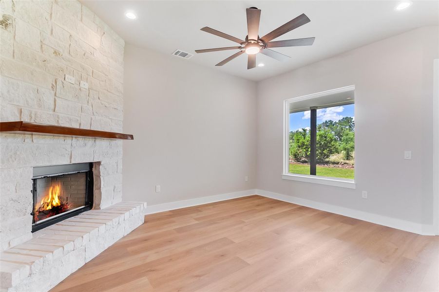 Unfurnished living room with light wood-style flooring, a fireplace, ceiling fan, and recessed lighting