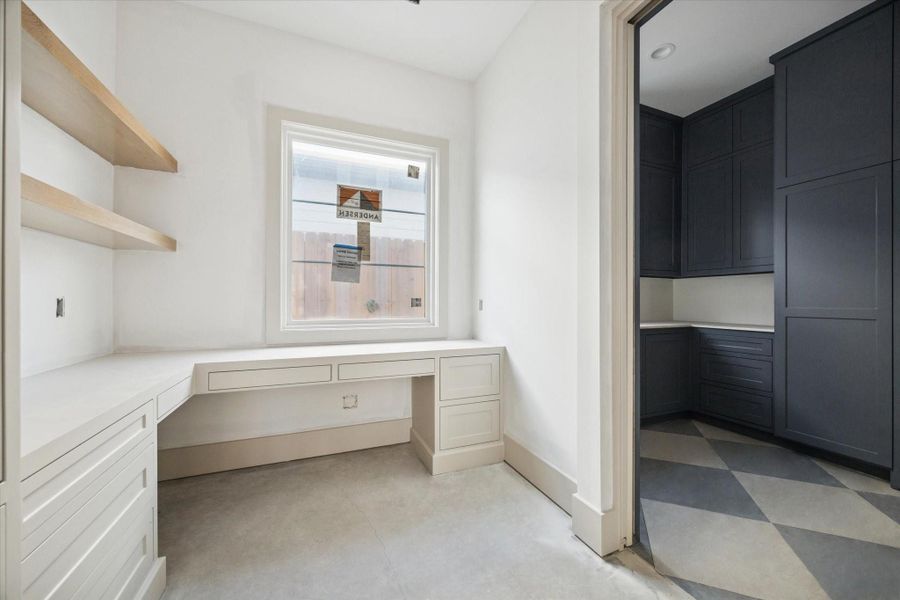 STUDY - Built in study nook pairs soft neutral cabinetry with warm wood shelving, creating a quiet workspace flooded with natural light. Clean lines, integrated storage, and durable flooring make the space ideal for focused work or daily organization without sacrificing design. -- Construction as of 1/5/26