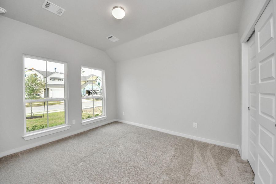 Secondary bedroom features plush carpeting, large windows that let in plenty of natural light, bright paint, and spacious closets. Sample photo of completed home with similar floor plan. Actual colors and selections may vary. Secondary bedroom features plush carpeting, large windows that let in plenty of natural light, bright paint, and spacious closets. Sample photo of completed home with similar floor plan. Actual colors and selections may vary.