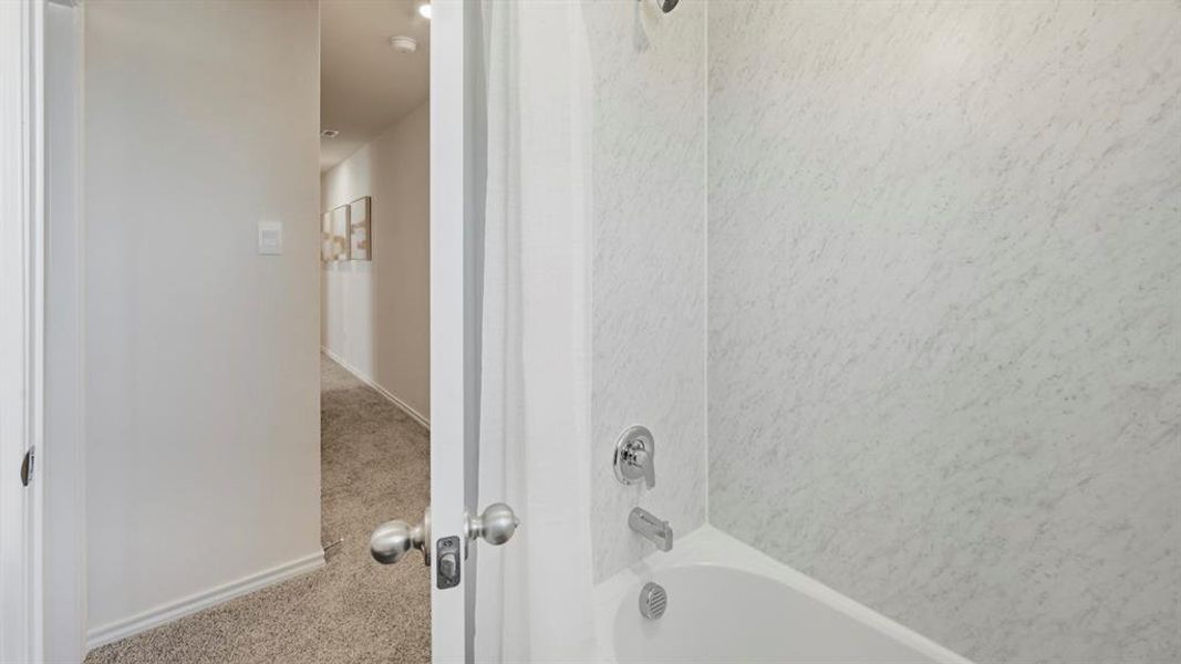 Bathroom featuring carpet floors and washtub / shower combination