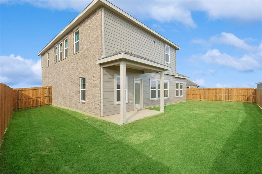 Back of property with a lawn and a patio area