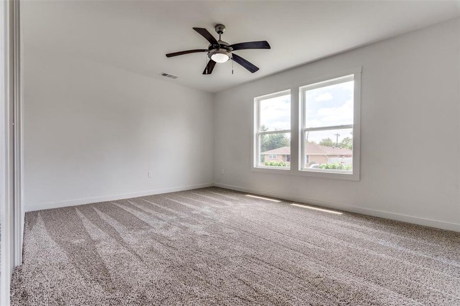 Carpeted empty room with ceiling fan