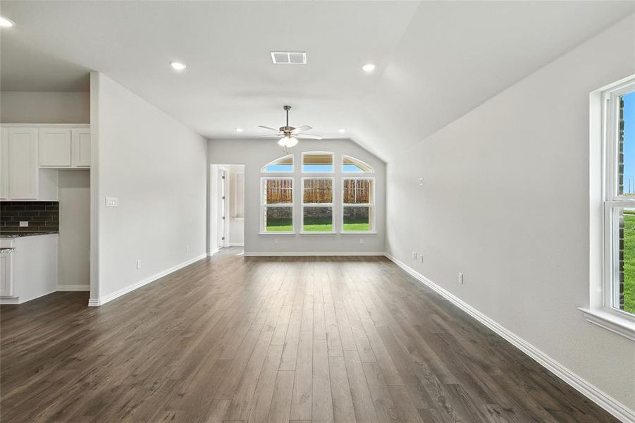 Unfurnished living room featuring ceiling fan, dark wood-style floors, lofted ceiling, and recessed lighting
