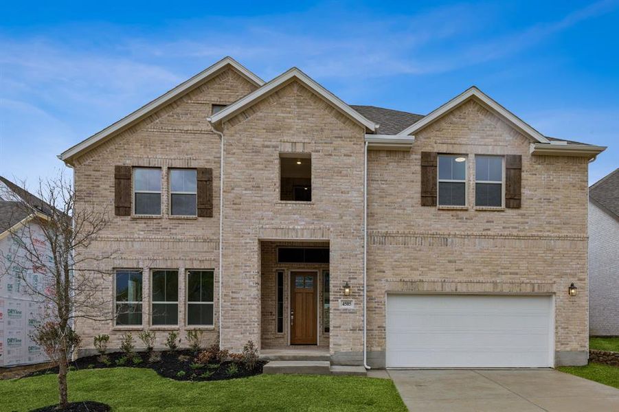View of front of house featuring concrete driveway, an attached garage, a front lawn, and brick siding