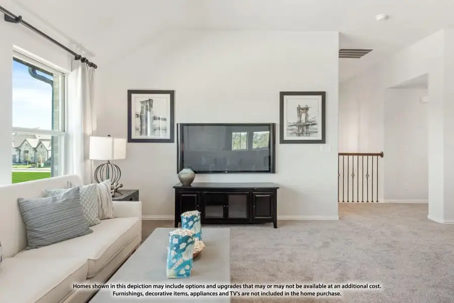 Upstairs living area with vaulted ceiling, wall-mounted TV, white sofa, and carpet flooring near staircase railing