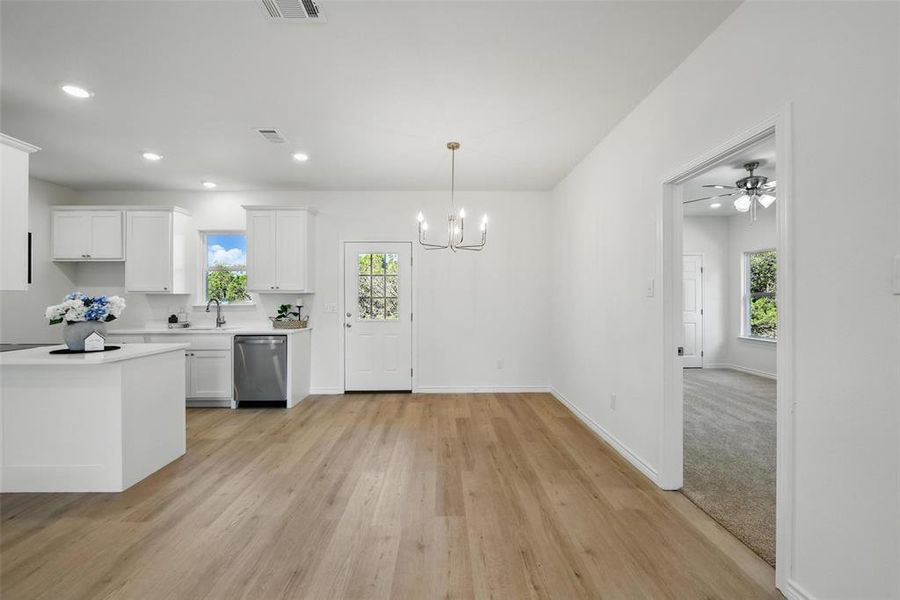 Kitchen with stainless steel dishwasher, light countertops, plenty of natural light, a chandelier, and recessed lighting Kitchen with stainless steel dishwasher, light countertops, plenty of natural light, a chandelier, and recessed lighting
