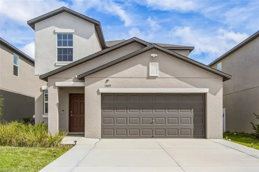 Front exterior of a new home in The Isle of Avalon, Spring Hill, FL, highlighting curb appeal (Image 2).
