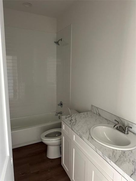 Full bathroom featuring shower / bath combination, vanity, and dark wood-style floors