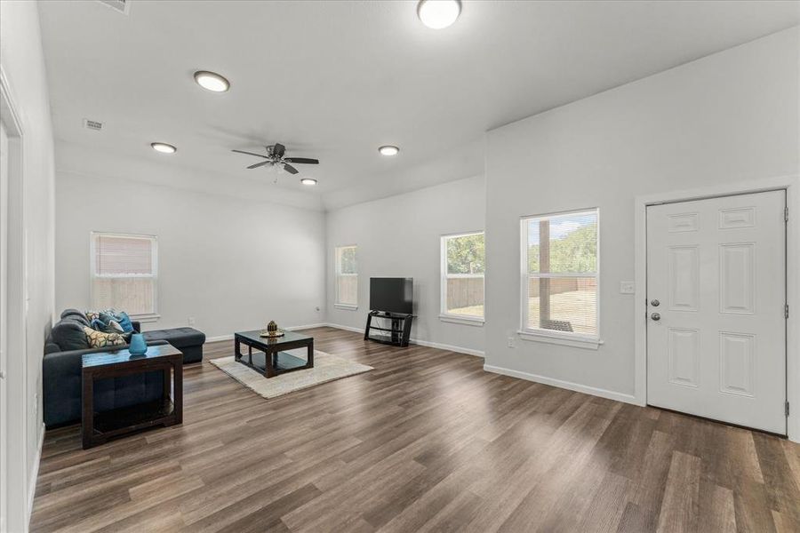 Living area with dark wood finished floors, ceiling fan, and recessed lighting