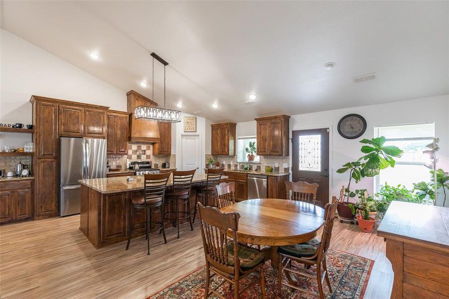 Spacious kitchen and dining area featuring vaulted ceilings and recessed lighting Spacious kitchen and dining area featuring vaulted ceilings and recessed lighting