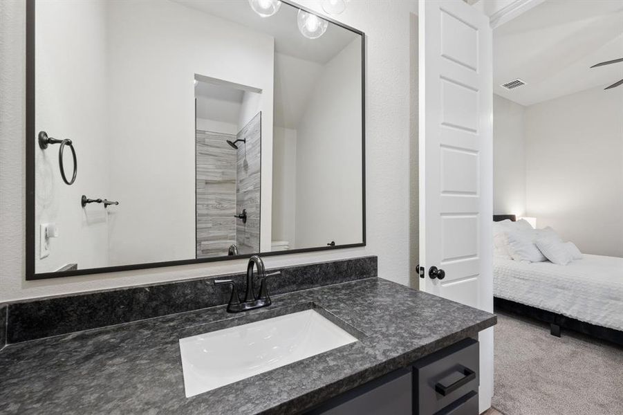 Ensuite bathroom with vanity, a shower, and carpet floors