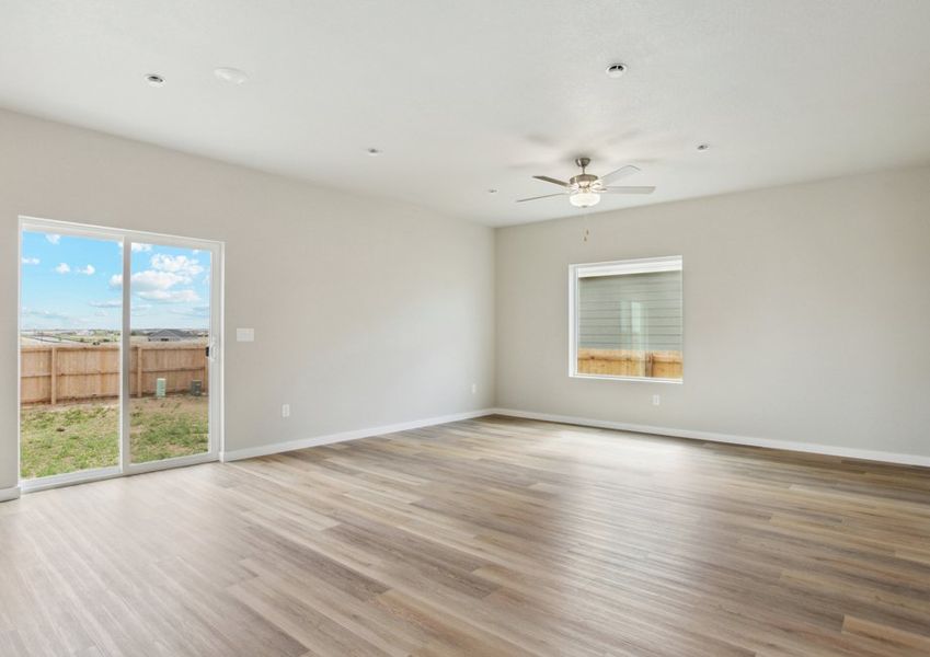 The family room is spacious with plank flooring and a ceiling fan.