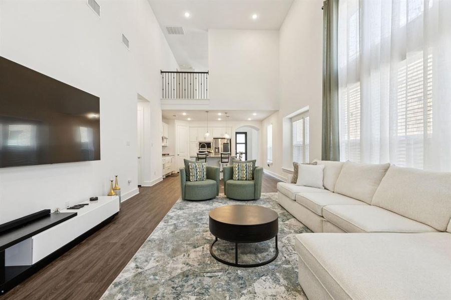 Living room with recessed lighting, dark wood finished floors, and a high ceiling Living room with recessed lighting, dark wood finished floors, and a high ceiling
