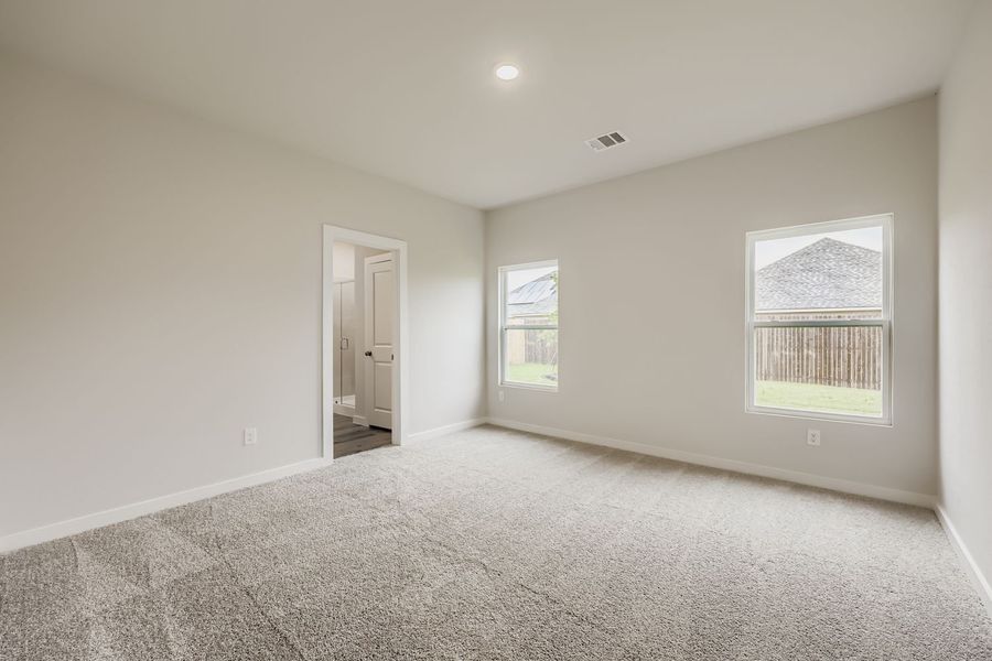A room with a carpet and windows.