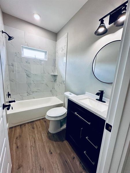 Full secondary bathroom with an oversized vanity, and cute round mirror. Shower and bathtub.