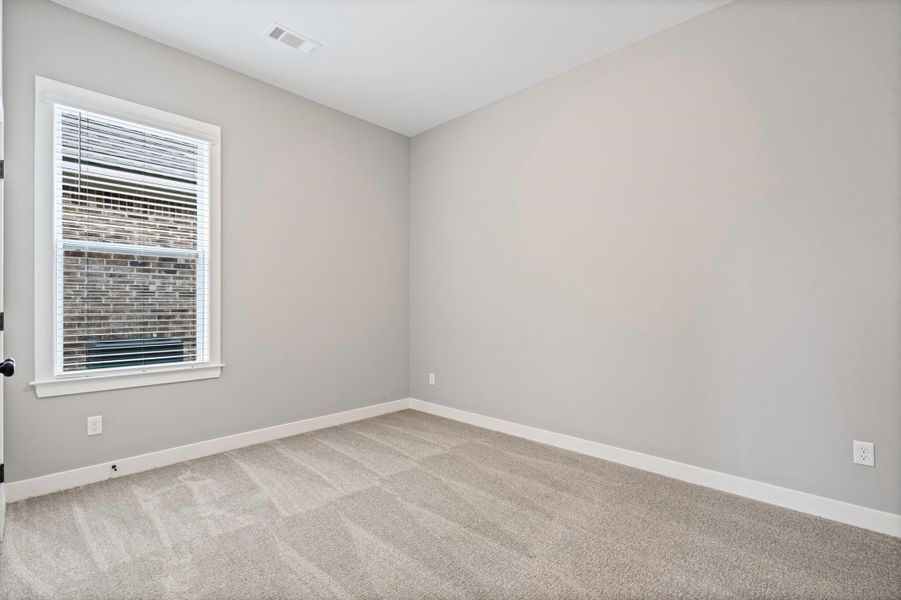 Neutral-toned room with light gray walls and patterned carpeting Neutral-toned room with light gray walls and patterned carpeting