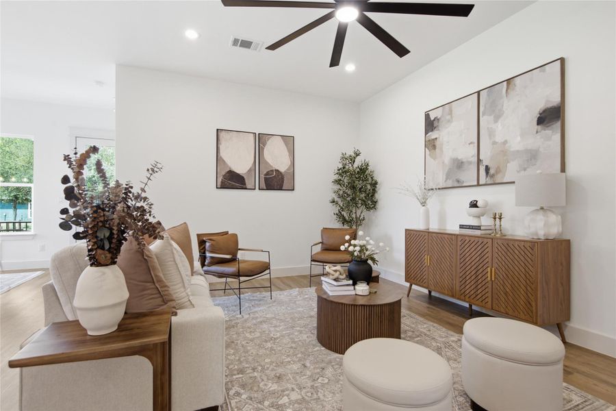 An inviting gathering space boasts hardwood flooring, recessed lighting, and a modern ceiling fan for optimal comfort. An inviting gathering space boasts hardwood flooring, recessed lighting, and a modern ceiling fan for optimal comfort.