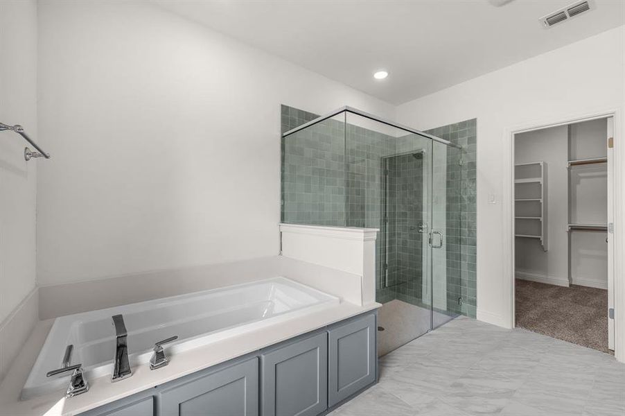 Full bathroom with a shower stall, a bath, a walk in closet, and recessed lighting