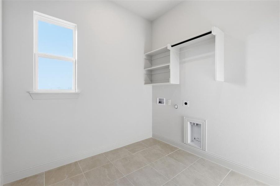 Laundry area with hookup for a gas dryer, hookup for an electric dryer, washer hookup, and light tile patterned flooring