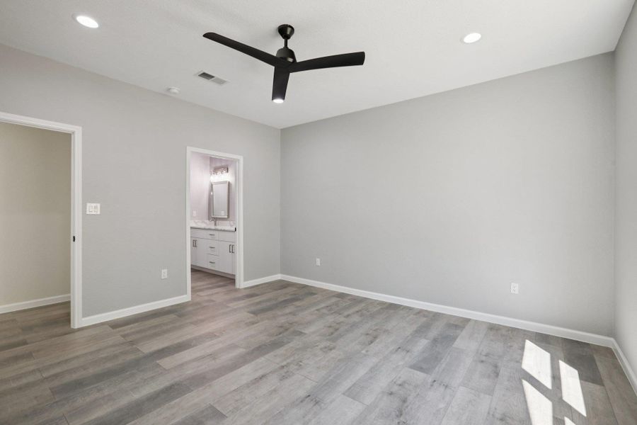 Primary Bedroom with ceiling fan, ensuite bath, recessed lighting, and light wood-type laminate flooring