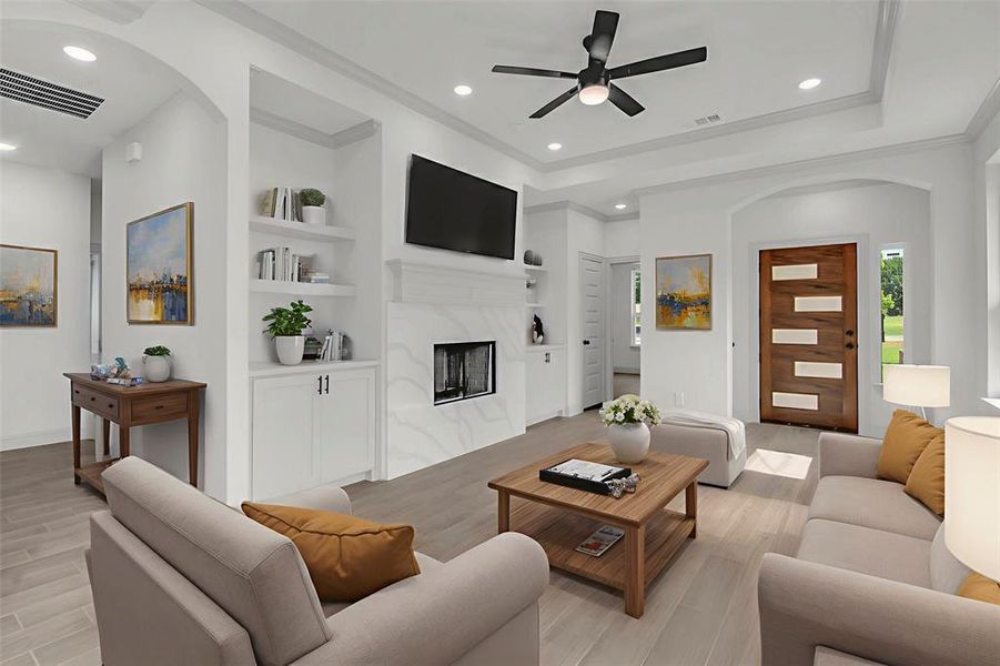 Living area featuring arched walkways, a ceiling fan, light wood finished floors, built in features, and recessed lighting, virtually staged Living area featuring arched walkways, a ceiling fan, light wood finished floors, built in features, and recessed lighting, virtually staged