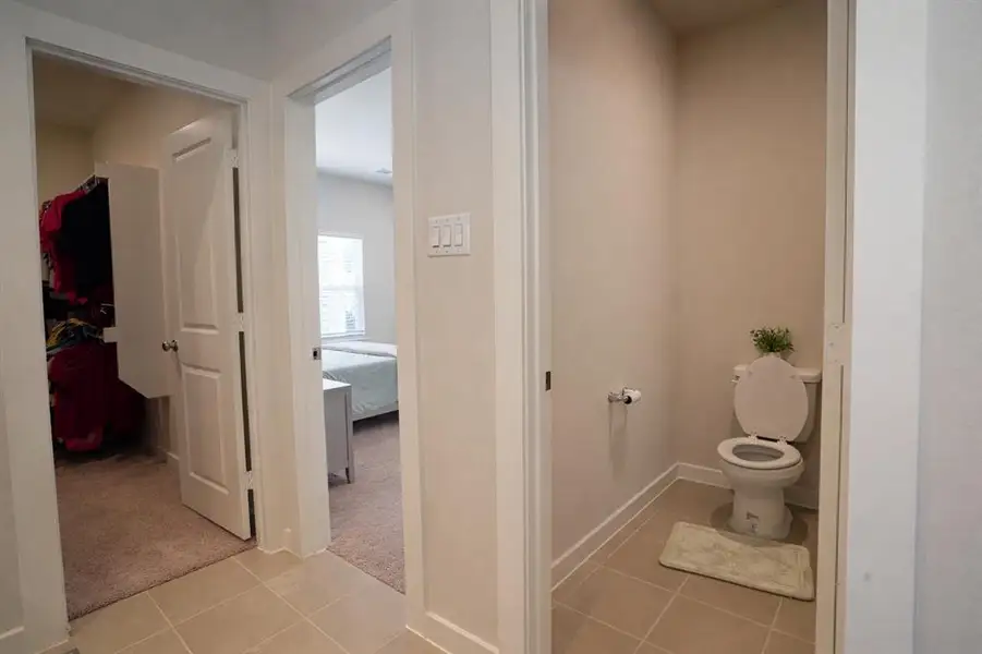 Bathroom featuring light tile patterned floors, ensuite bathroom, and light carpet
