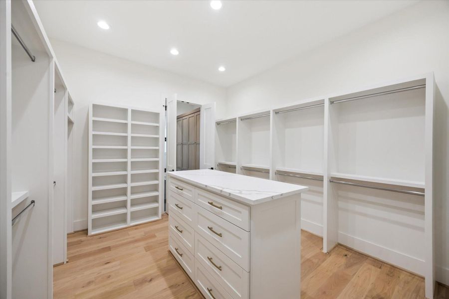 Large walk in closet with center island shelving, T-shirt / Shoe storage and great amount of hanging space. Large walk in closet with center island shelving, T-shirt / Shoe storage and great amount of hanging space.