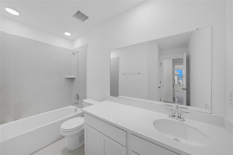 Full bath with washtub / shower combination, vanity, light tile patterned floors, and recessed lighting Full bath with washtub / shower combination, vanity, light tile patterned floors, and recessed lighting