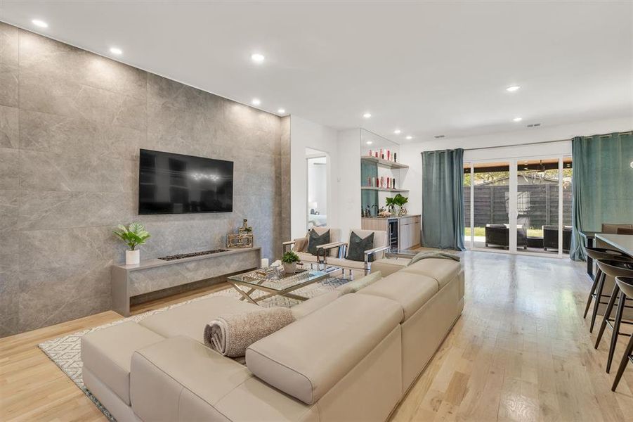 Living room featuring light hardwood / wood-style floors and tile walls