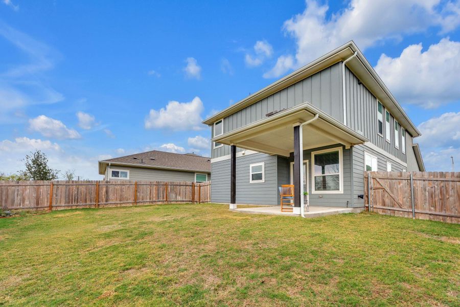 Back of property with a patio, board and batten siding, and a fenced backyard
