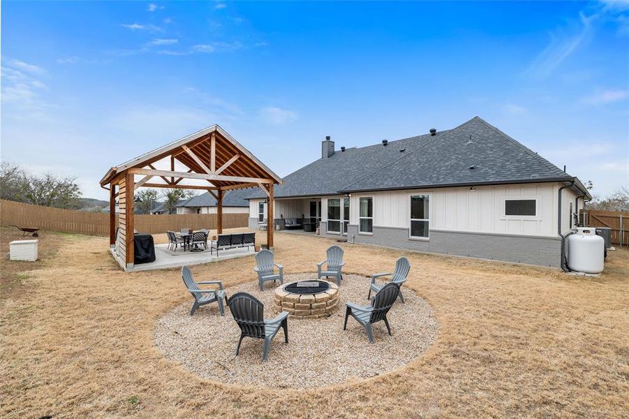 Rear view of property featuring a gazebo, a patio, and an outdoor fire pit