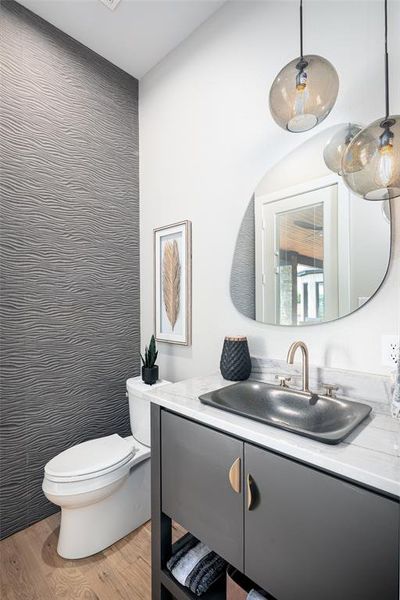 Bathroom with hardwood / wood-style floors, vanity, and toilet