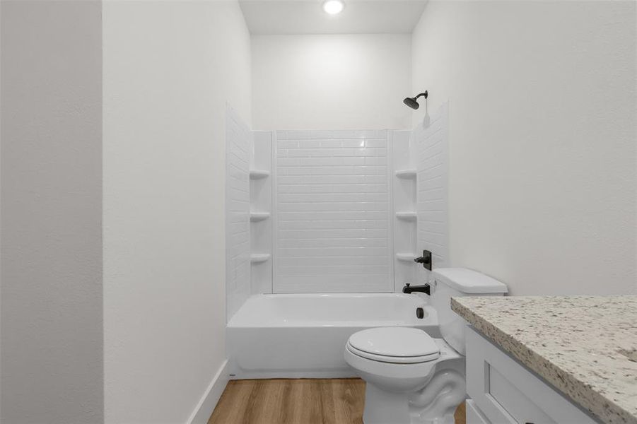 Full bathroom with toilet, vanity, bathing tub / shower combination, and hardwood / wood-style floors