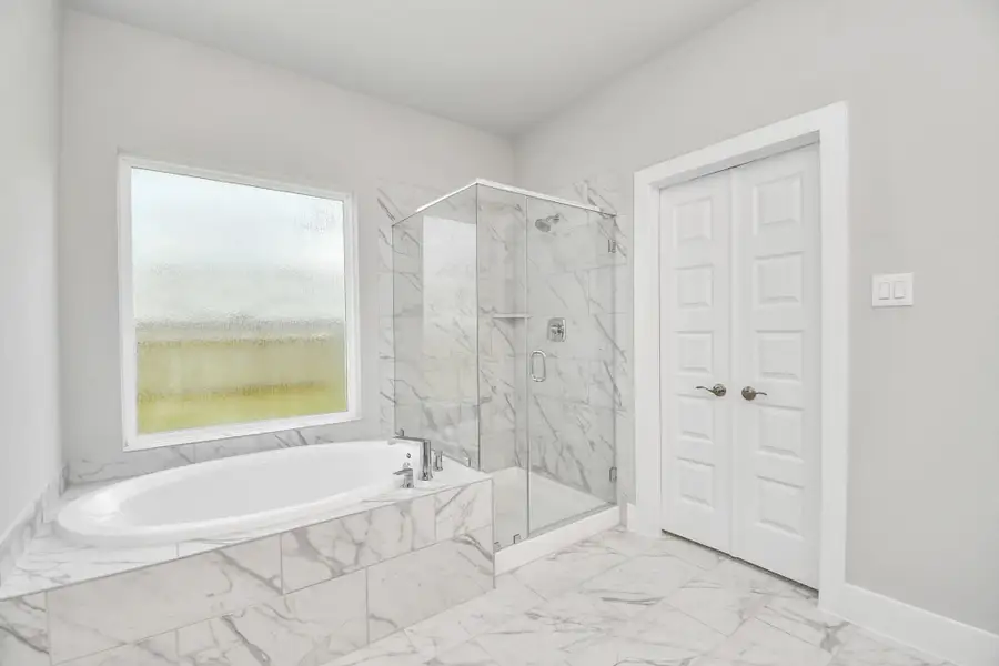 This additional view of the primary bath features a walk-in shower with the tile surround and separate garden tub perfect for soaking after a long day. This additional view of the primary bath features a walk-in shower with the tile surround and separate garden tub perfect for soaking after a long day.