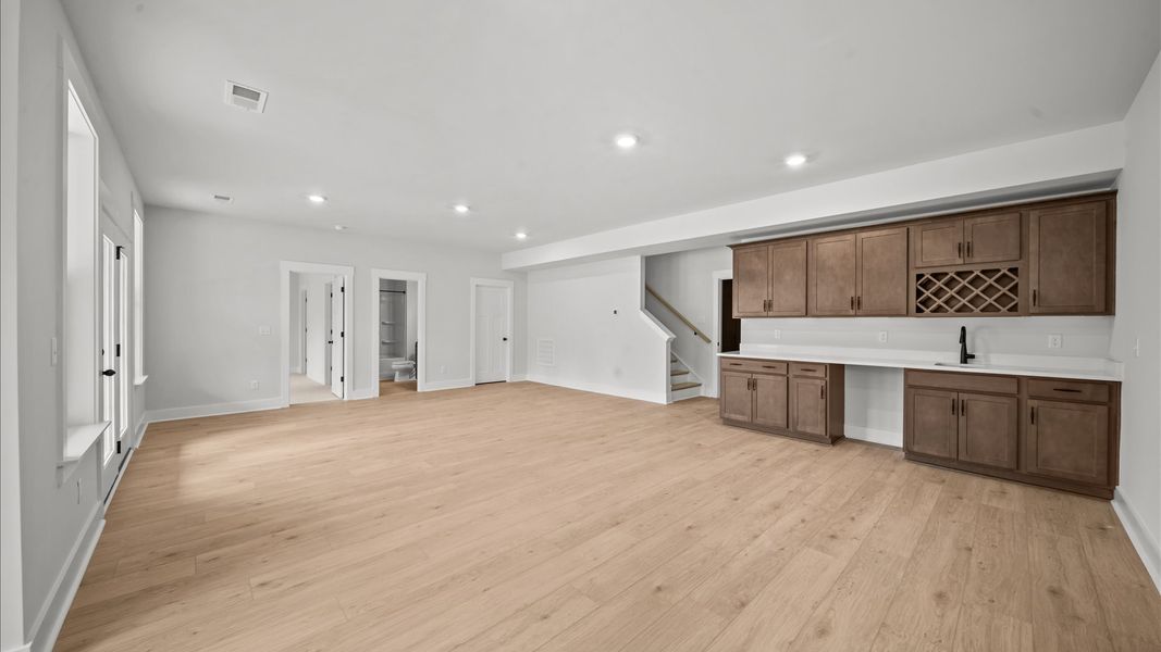 Hardwood flooring and a stylish wet bar make this finished basement ideal for hosting