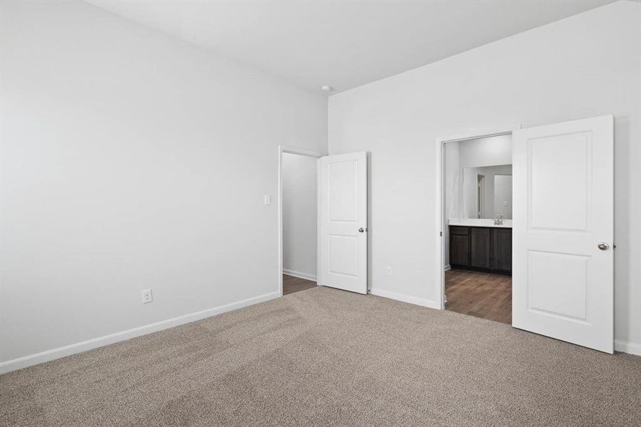 Unfurnished bedroom featuring carpet floors and ensuite bath Unfurnished bedroom featuring carpet floors and ensuite bath