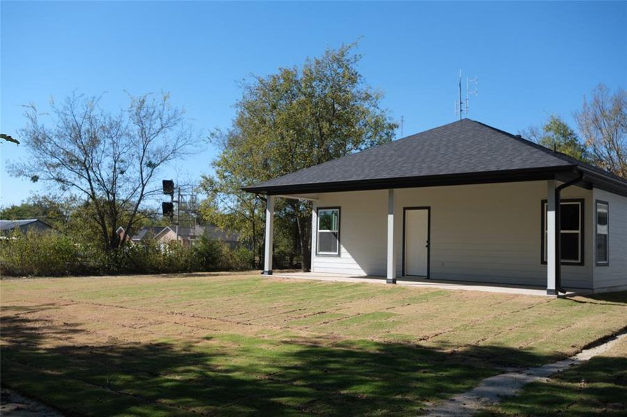 Back of property featuring a lawn, a shingled roof, and a porch Back of property featuring a lawn, a shingled roof, and a porch