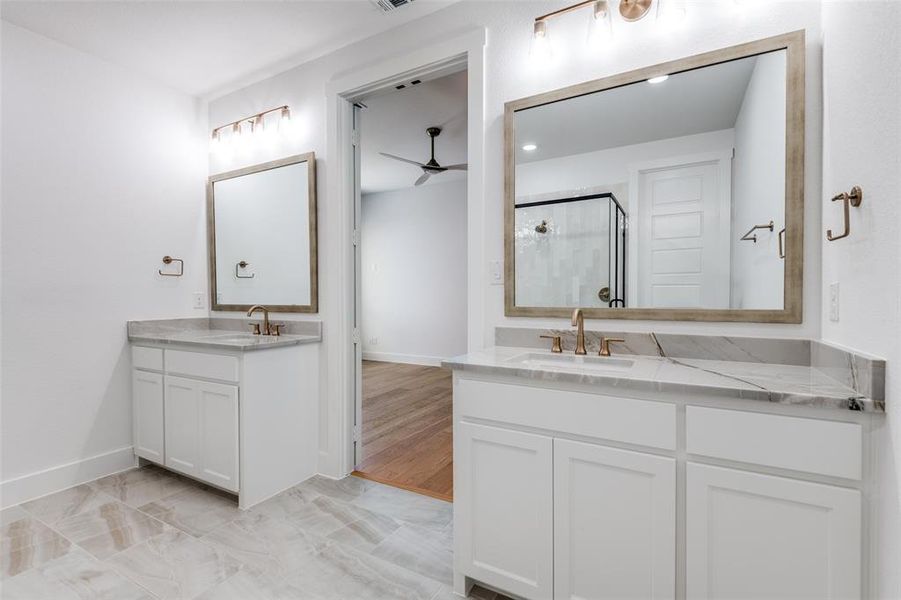 Bathroom featuring ceiling fan, double vanity, and tile patterned floors