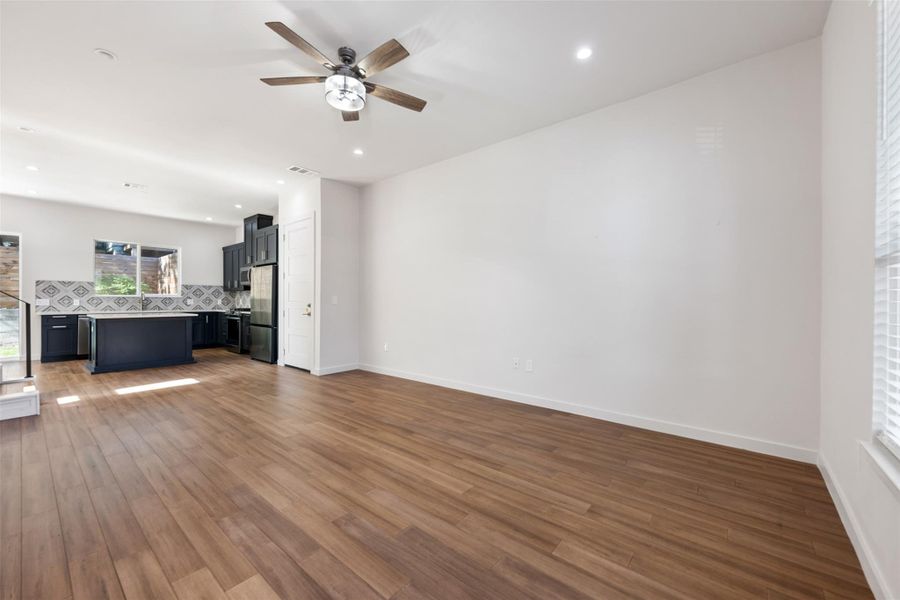 Unfurnished living room featuring a ceiling fan, dark wood-style floors, and recessed lighting