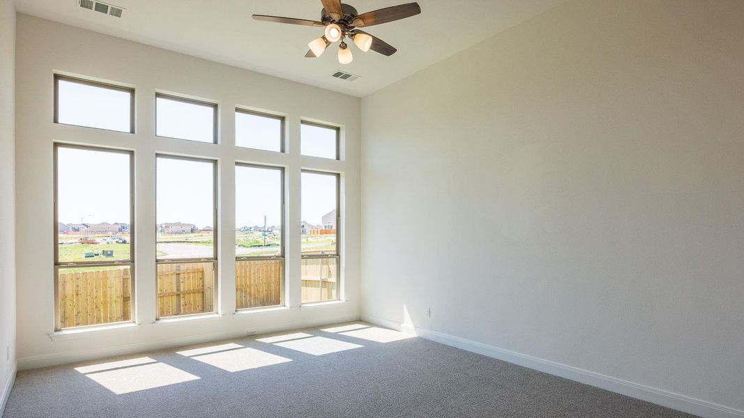 Spare room featuring a residential view, carpet floors, and ceiling fan Spare room featuring a residential view, carpet floors, and ceiling fan