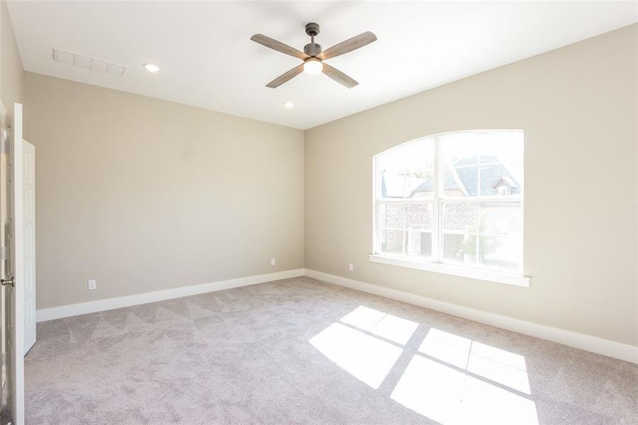 Carpeted spare room featuring ceiling fan