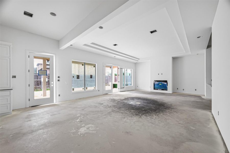 Spacious living room featuring soaring high ceilings and tray ceiling details