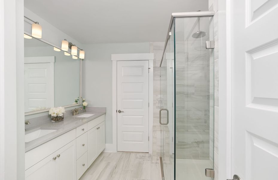 Owner's Suite Bath with oversized walk-in tile shower equipped with dual shower heads and bench, spacious walk-in closet Owner's Suite Bath with oversized walk-in tile shower equipped with dual shower heads and bench, spacious walk-in closet