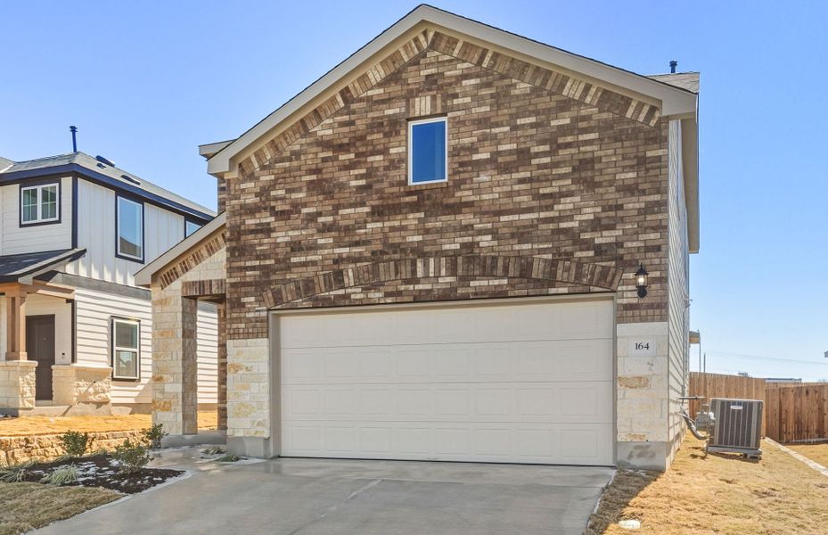 Front exterior of a new home in Sunfield, Buda, TX, highlighting curb appeal (Image 18).