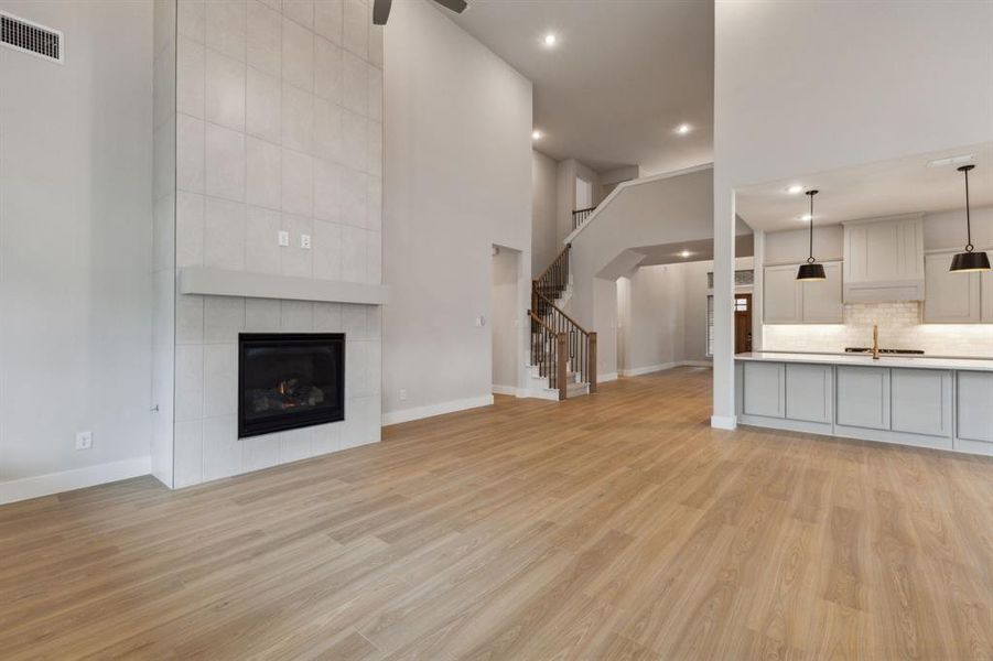 Unfurnished living room with recessed lighting, light wood-type flooring, stairway, a fireplace, and a ceiling fan